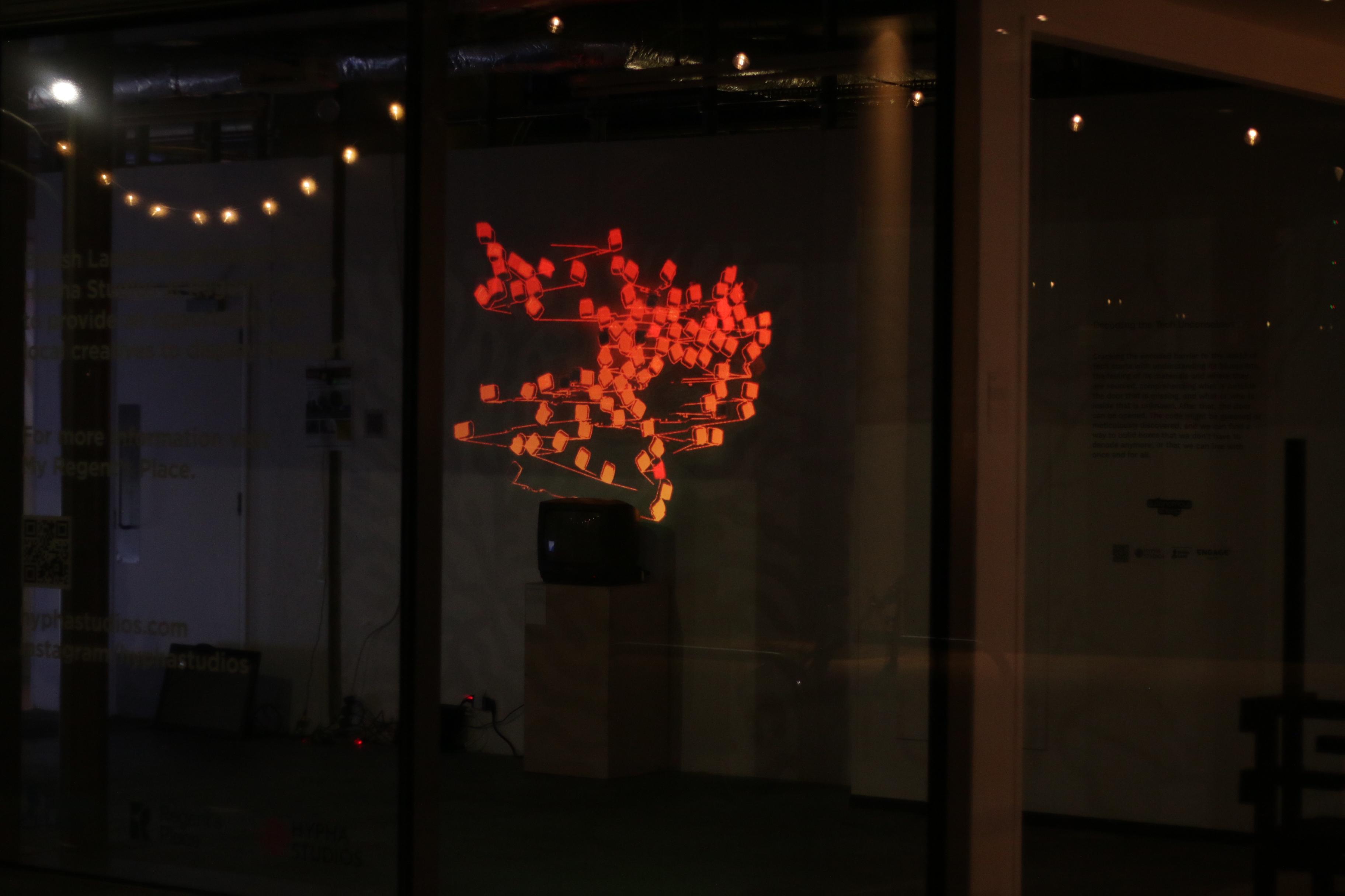 An image of the art piece at night from outside the gallery space.